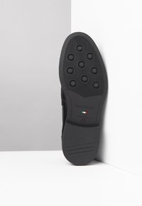 Suola di scarpa nera con puntini di gomma circolari, presenta un logo impresso e il tricolore italiano. Fabricata in Italia, con taglia 42 indicata.