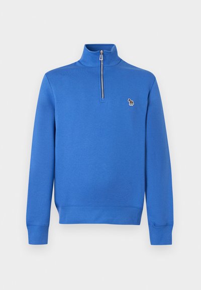 Μπλε φούτερ με μακριά μανίκια και φερμουάρ στο ένα τέταρτο, με όρθιο γιακά και μικρό πολύχρωμο patch ζέβρας στο αριστερό στήθος.