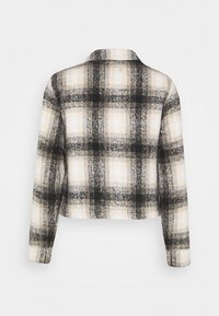 Casaco cropped em padrão xadrez preto e creme, feito de tecido texturizado, com gola e mangas longas. Vista traseira mostrada.