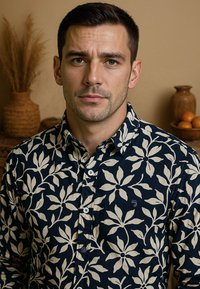 Marineblauw shirt met een crèmekleurig bloemenpatroon, met knoopsluiting en kraag. Bevat een klein logo en een stoffen textuur die een lichtgewicht gevoel geeft.