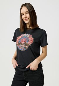 Camiseta de algodón negra con un vibrante diseño gráfico multicolor con formas abstractas y motivos de sol en el frente. Mangas cortas.