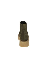 Bottines en daim vert avec une finition texturée, des côtés élastiques et une semelle en caoutchouc épaisse et de couleur claire. La vue arrière met en avant un design minimaliste.