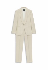 Beżowy dwuczęściowy garnitur z jednoprzyciskową marynarką z kołnierzem szalowym i dopasowanymi, wąskimi spodniami, ułożony na płasko na białym tle.