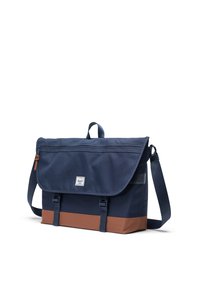 Borsa a tracolla navy con pannello inferiore marrone, tracolla regolabile, chiusura a patta magnetica e patch logo frontale. Tessuto strutturato con finitura liscia.