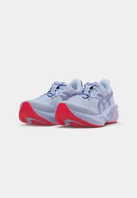 Pantofi sport bleu deschis cu un superior texturat, accente purpurii și o talpă roșie. Prezintă o talpă intermediară căptușită și închidere cu șireturi.