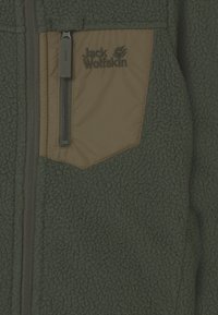 Chaqueta de forro polar verde con un bolsillo en el pecho con cremallera en color marrón y con el logo de Jack Wolfskin, que presenta una superficie de tejido texturizado.