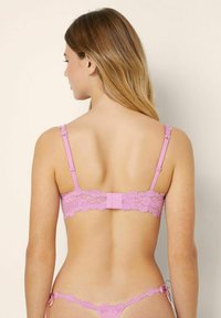 Rosa spetsbralette med justerbara axelband, blommönster och hakstängning bak. Mjuk textur med intrikata mönsterdetaljer.