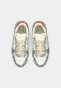 Pair of Veja sneakers in white and gray with beige laces, perforated toe boxes, and red accents on the heel collars, viewed from above.