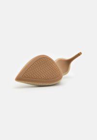 High-heeled shoe with a textured, light brown rubber sole and a pointed toe. Upper features a shimmering beige material.