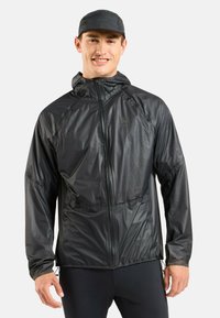 Schwarze, leichte Jacke mit hohem Kragen, Reißverschluss vorne und verstellbarem Saum. Sie bietet eine glatte, glänzende Textur mit minimaler Markenkennzeichnung.