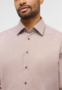 Lichtroze button-up shirt van fijn textiel, met een spreidkraag en ronde knopen met een contrasterend kleurdetail.