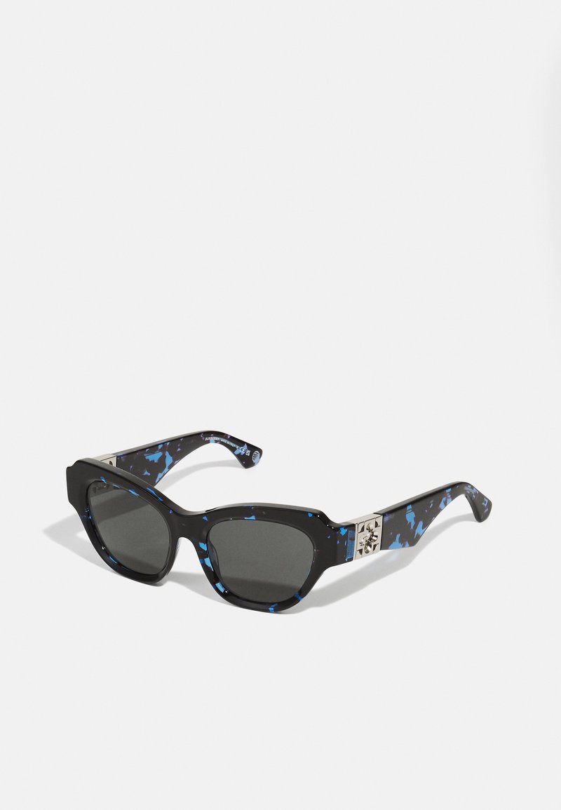 Occhiali da sole neri con motivo a macchie blu. Design della montatura angolare, lenti grigie e dettagli metallici sulle astine.