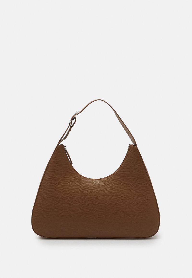 Sac à main en cuir marron texturé avec une bandoulière réglable unique et une fermeture éclair sur un fond clair uni.