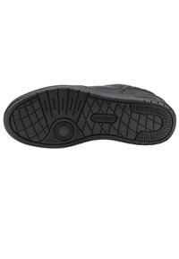 Black rubber shoe sole with a textured grip pattern, featuring a circular detailing and the brand name "LACOSTE" in a rectangular accent.