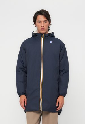 Navy blue parka with a white fur-lined hood, yellow and orange zipper, and elastic cuffs. Features a logo on the chest for branding.