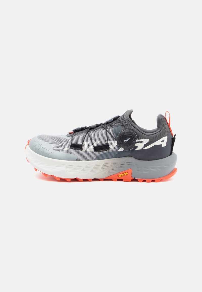 Baskets de sport grises avec une tige en maille texturée, des accents noirs, une semelle orange et un système de laçage Boa. Présente un avant-pied plus large et une semelle intermédiaire rembourrée.