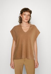 Top castanho, tricotado, de mangas curtas com decote em V e gola. Tecido leve com uma textura suave, design em camadas e corte relaxado.