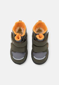 Dunkelgrüne und graue Kinderstiefel mit orangefarbenem Fleece-Innenfutter, Klettverschlüssen, strukturiertem Stoff und Gummisohlen.