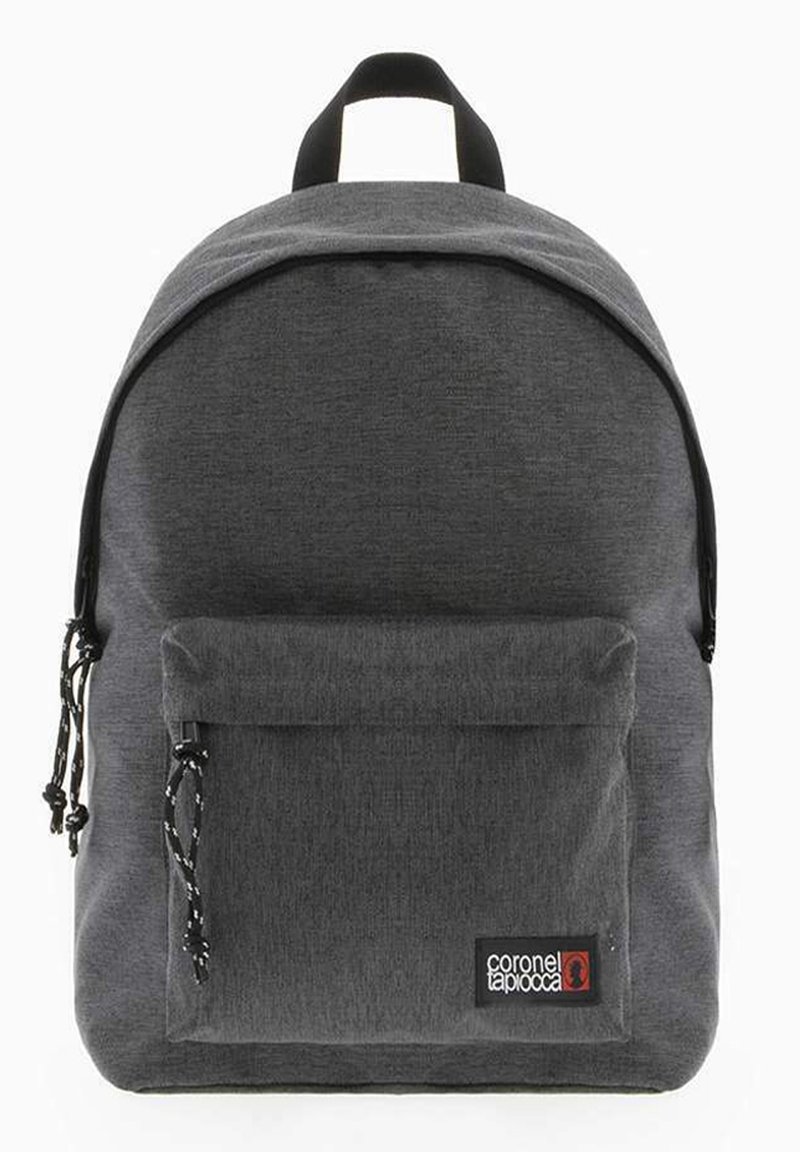 Mochila de tela gris con parte superior redondeada, bolsillo frontal con cremallera, correas ajustables, acentos negros y una etiqueta de logo en la parte delantera.