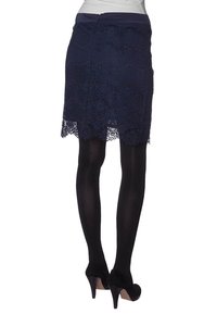 Navy lace pencil skirt with scalloped hem, joka sisältää sileän vyötärön ja teksturoidun kukkakuosin. Yhdistetty mustien opasivien legginsien ja korkokenkien kanssa.