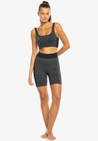 Schwarzes Sport-Bustier und hochtaillierte Shorts im Set. Verfügt über ein geometrisches Design, eine weiche Textur und eine nahtlose Verarbeitung für maximalen Komfort.