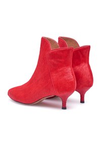 Rode enkellaarsjes gemaakt van getextureerd haarleer, met een spitse neus, uniek ontwerp aan de achterkant en slanke, lage kittenhakken.