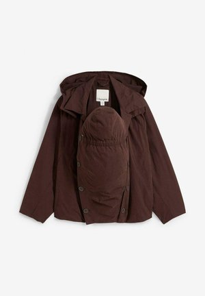 Braune Kapuzenjacke mit einer vorn angebrachten, mit Knöpfen verschlossenen Babytrage, flach auf einem weißen Hintergrund ausgelegt.