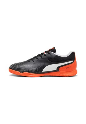 Zapatillas deportivas negras y naranjas con superficie texturizada, acentos blancos, puntera redondeada y suela de goma con un patrón de agarre detallado.