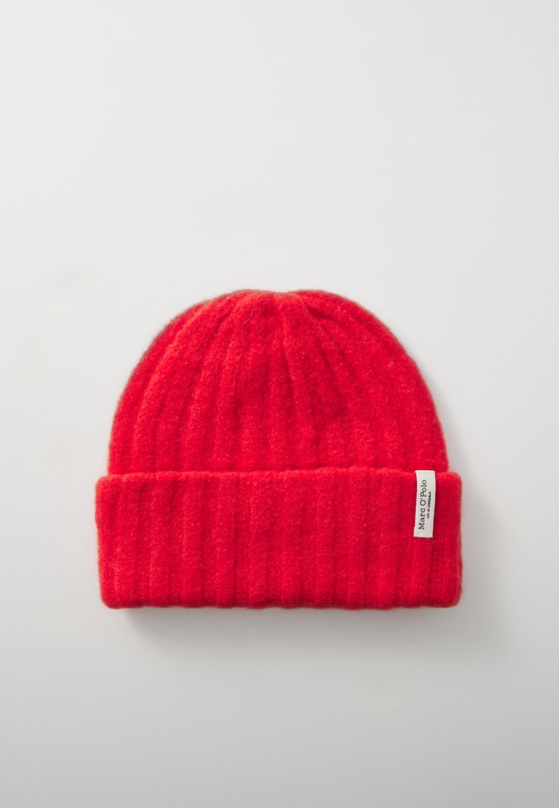 Red knitted beanie with a ribbed texture. Features a folded cuff and a small white label on the side. Soft wool material.