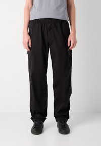 Schwarze Cargo-Hosen mit elastischem Bund, Seitentaschen und lässigem Schnitt. Hergestellt aus robustem Stoff, der ein praktisches Design bietet.