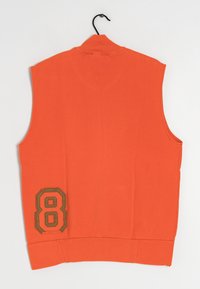 Ärmlös orange väst med hög krage. Har ett brunbroderat "8"-märke på vänster sida och en slät yta. Hänger på en krok.