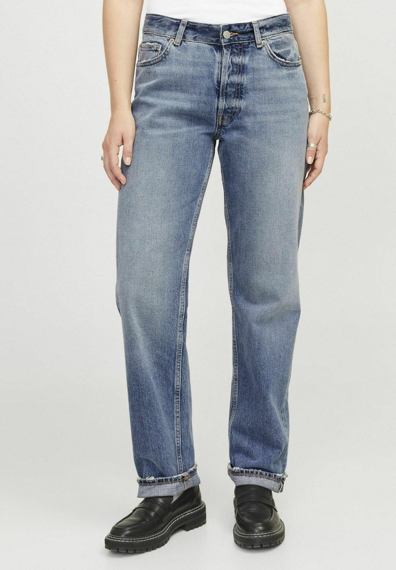 Jeans de mezclilla azul con un diseño de pierna recta, ligero desteñido y dobladillos rematados. Presenta un clásico cierre de botones y estilo de cinco bolsillos.
