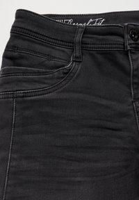 Svarta denimjeans med en slät textur, som har hög midja, sömnadsdetaljer och en knappstängning framtill.