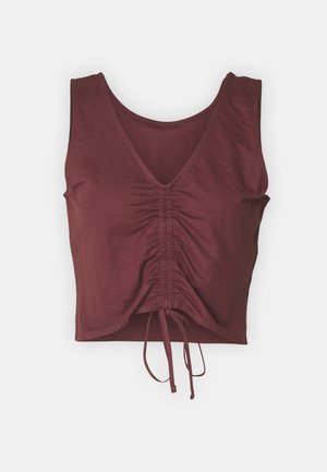 Μαρούλι crop top με V λαιμόκοψη, κοντά μανίκια, μαζεμένη λεπτομέρεια στο μπροστινό μέρος και ρυθμιζόμενο κορδόνι στο τελείωμα. Λείο υλικό.