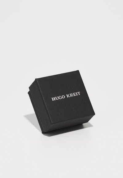 Scatola regalo rettangolare nera con una finitura testurizzata, caratterizzata dal nome embossato "HUGO KREIT" in argento sul coperchio.