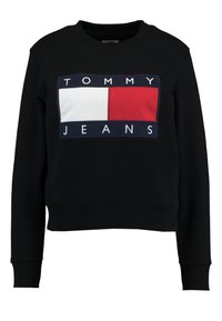 Musta huppari pyöreällä kauluksella, jossa on suorakulmainen logo punaisena, valkoisena ja tummansinisenä "TOMMY JEANS" -tekstillä. Pehmeä, puuvillamainen pinta.