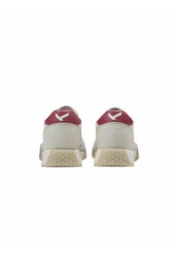 Scarpe da ginnastica bianche con una tomaia morbida e strutturata e un accento rosso sul tallone. Suola in gomma con pattern esagonale che offre aderenza e stabilità.