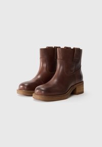 Braune Leder-Ankle-Boots mit abgerundeter Zehenpartie, niedrigem Blockabsatz und seitlichen Riemen. Glatte Textur mit einem kontrastierenden matten Finish.