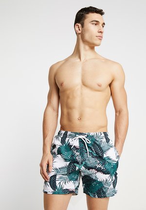 Men's swim trunks with a tropical leaf print in green and white, featuring an elastic waistband and drawstring for adjustment.