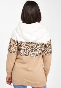 Sudadera con capucha que presenta una sección superior blanca, una parte media con estampado de leopardo y una sección inferior beige. Tejido suave con puños y dobladillo acanalados.