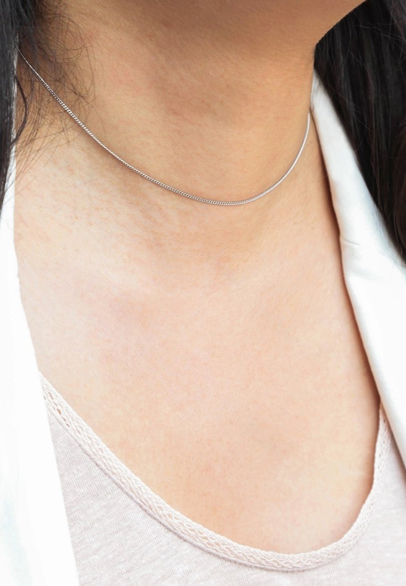 Zilveren choker ketting met een fijne, gladde ketting. Dicht bij de nek gedragen, heeft het een minimalistisch ontwerp zonder versieringen.
