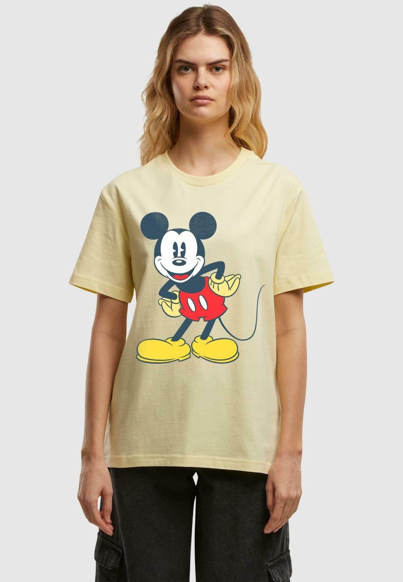 Yellow cotton t-shirt featuring a large graphic of a cartoon mouse with black ears, red shorts, and yellow shoes. Short sleeves and round neckline.