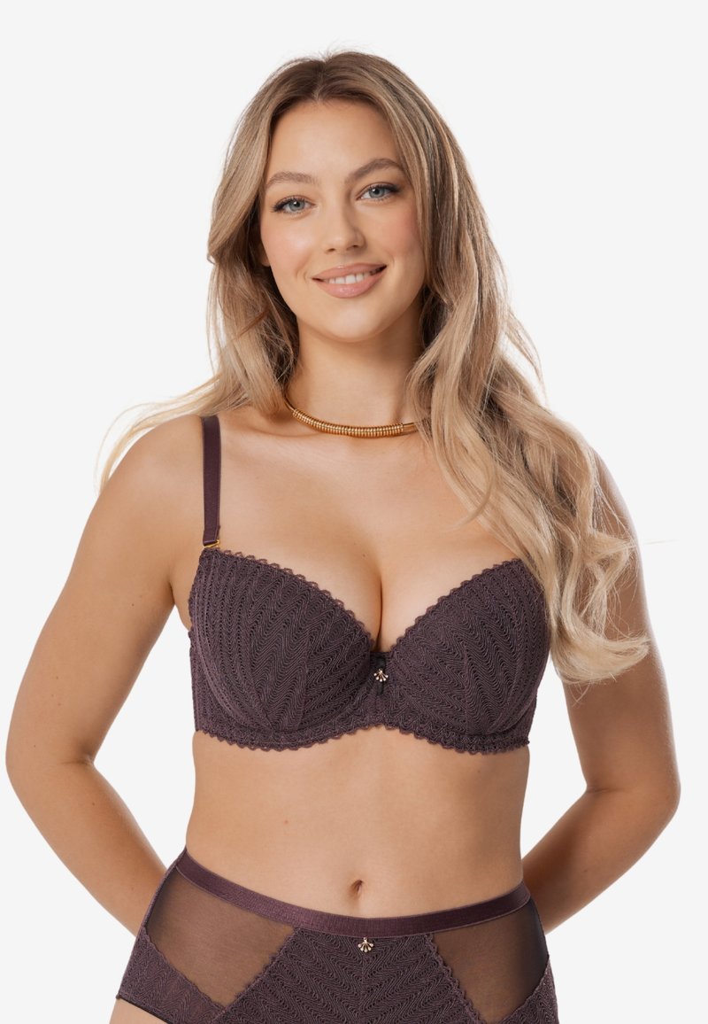 Czarny koronkowy stanik w odcieniu ciemnofioletowym z falbaniastymi krawędziami i centralnym ozdobnym akcentem. Posiada regulowane ramiączka oraz gładki, teksturowany wzór.