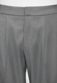 Grå skræddersyede bukser med en glat tekstur, der har en flad front, pæne syninger og en slim fit.