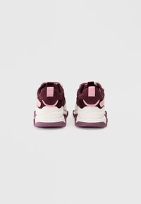 Vue arrière de baskets présentant un dessus bourgogne avec des textures en maille et en suède, des accents roses et une semelle intermédiaire blanche avec une semelle extérieure violette.