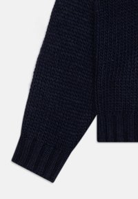 Pull en maille bleu marine avec un motif texturé, doté de poignets et d'un ourlet côtelés. Le tissu a l'air épais et chaud, adapté aux temps plus froids.