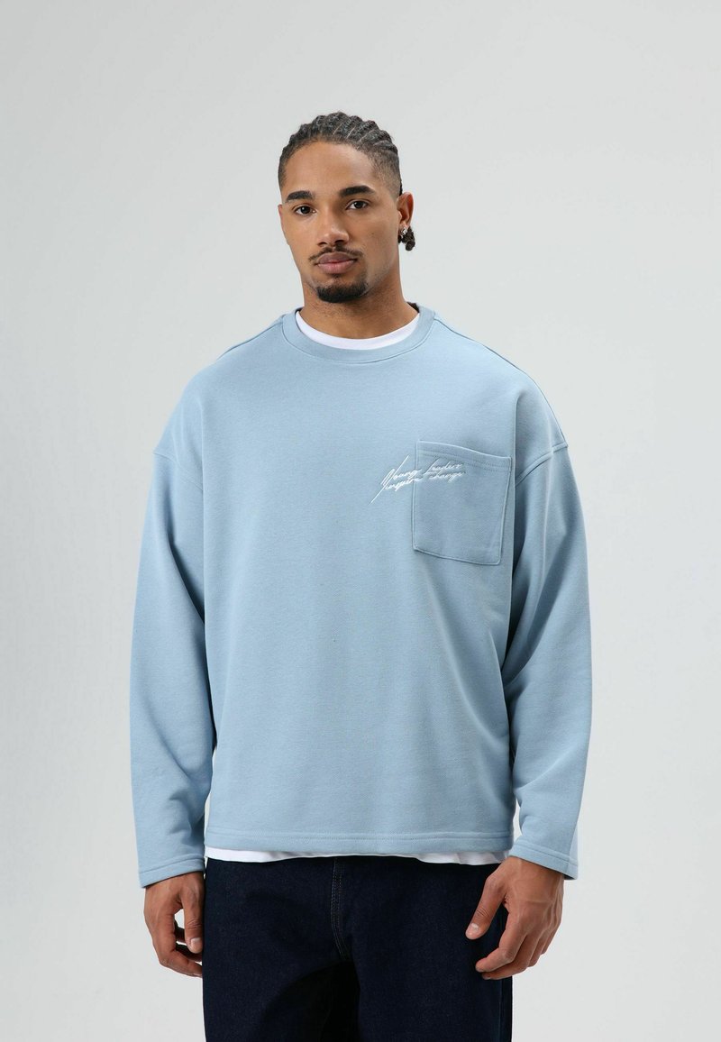 Lichtblauwe sweatshirt van zachte stof, met een borstzak en geborduurde details. Lange mouwen met geribbelde boorden, comfortabele pasvorm.