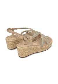 Sandales compensées beiges avec des lanières scintillantes, en daim doux et détails en jute, dotées d'une semelle intérieure rembourrée et d'une sangle ajustable à la cheville.