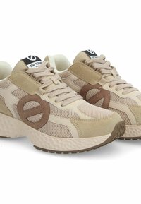 Scarpe sportive beige realizzate in materiali mesh e suede, con un accentuato logo rotondo e suola testurizzata, lacci beige e colletto imbottito.