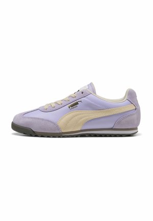 Baskets Puma Arizona profil bas en violet clair avec des accents en daim beige et une semelle noire texturée vues de côté.